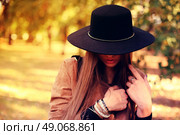 Street fashion concept - closeup portrait of a pretty girl. Wearing hat and suede jacket holding bag with fringe. Beautiful autumn woman. . Стоковое фото, агентство Ingram Publishing / Фотобанк Лори