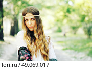 Fashion portrait of beautiful hippie young woman wearing boho chic clothes and summer hat outdoors. Soft warm vintage color tone. Artsy bohemian style. Стоковое фото, агентство Ingram Publishing / Фотобанк Лори