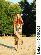 Fashion portrait of beautiful hippie young woman wearing boho chic clothes, chiffon cardigan and boho chic style bijouterie. Blonde haired woman dressed in bohemian style at the beach. Стоковое фото, агентство Ingram Publishing / Фотобанк Лори