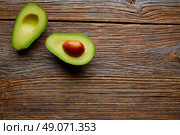 avocado cut on aged wood table board cutted half. Стоковое фото, агентство Ingram Publishing / Фотобанк Лори