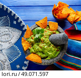 Guacamole with nachos avocado in Mexican molcajete and Sombrero hat. Стоковое фото, агентство Ingram Publishing / Фотобанк Лори