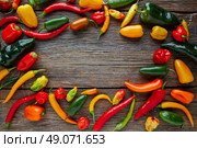 Mexican hot chili peppers colorful mix habanero poblano serrano jalapeno on wood. Стоковое фото, агентство Ingram Publishing / Фотобанк Лори