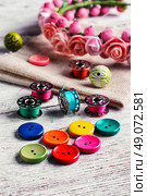 Buttons of different colors and accessories for needlework. Bright buttons and thread. Стоковое фото, агентство Ingram Publishing / Фотобанк Лори