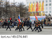 Военный парад в Магадане в честь Дня Победы. Знаменосцы с флагом России и знаменем Победы. На дальнем плане губернатор Магаданской области Сергей Носов. На трибунах зрители и участники СВО. 9 мая 2025 года. Празднование 80-летия победы Красной армии и советского народа над нацистской Германией в Великой Отечественной войне 1941–1945 годов. Площадь Горького, город Магадан, Магаданская область, Россия. Редакционное фото, фотограф Андрей Степанов / Фотобанк Лори