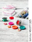 Threads and a set of buttons and bobbin on a bright light background. Working inventory seamstresses. Стоковое фото, агентство Ingram Publishing / Фотобанк Лори