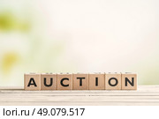 Auction sign on a vintage table on green background. Стоковое фото, агентство Ingram Publishing / Фотобанк Лори