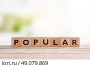 Popular sign made of cubes on a table with planks. Стоковое фото, агентство Ingram Publishing / Фотобанк Лори