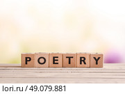 Poetry word made of wooden cubes on a desk. Стоковое фото, агентство Ingram Publishing / Фотобанк Лори