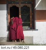Buddhist monks at Chimi Lhakhang, Punakha, Bhutan. Стоковое фото, агентство Ingram Publishing / Фотобанк Лори