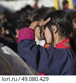 Teenage girl watching with shielding eyes, Paro, Bhutan. Стоковое фото, агентство Ingram Publishing / Фотобанк Лори