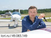 Man holding sunglasses, leaning on aircraft. Стоковое фото, агентство Ingram Publishing / Фотобанк Лори