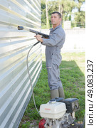 Man using pressure washer. Стоковое фото, агентство Ingram Publishing / Фотобанк Лори