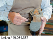 Cobbler mending sole of shoe. Стоковое фото, агентство Ingram Publishing / Фотобанк Лори
