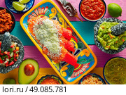 Red enchiladas Mexican food with guacamole and sauces on colorful table. Стоковое фото, агентство Ingram Publishing / Фотобанк Лори