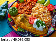 Chili relleno chili pepper poblano filled with cheese in dish with with rice and frijoles beans. Стоковое фото, агентство Ingram Publishing / Фотобанк Лори