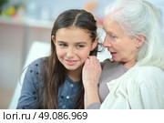 Little girl and grandma whispering secrets. Стоковое фото, агентство Ingram Publishing / Фотобанк Лори