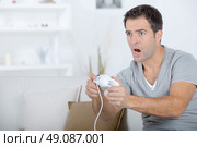 Man playing computer game, excited. Стоковое фото, агентство Ingram Publishing / Фотобанк Лори