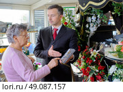 Funeral director showing woman a memorial plaque. Стоковое фото, агентство Ingram Publishing / Фотобанк Лори