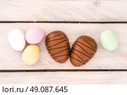 Easter candy eggs in various colors on a wooden table. Стоковое фото, агентство Ingram Publishing / Фотобанк Лори