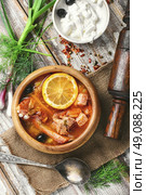 National Ukrainian soup Solyanka. Traditional solyanka with smoked meats in wooden plate. Стоковое фото, агентство Ingram Publishing / Фотобанк Лори