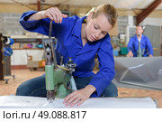 using an industrial puncher. Стоковое фото, агентство Ingram Publishing / Фотобанк Лори
