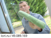 Man cleaning a window pane. Стоковое фото, агентство Ingram Publishing / Фотобанк Лори