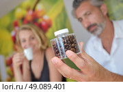 Man holding a transparent jar of coffee beans. Стоковое фото, агентство Ingram Publishing / Фотобанк Лори