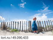 Toddler holding on to a picket fence on a beach. Стоковое фото, агентство Ingram Publishing / Фотобанк Лори