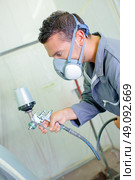 Mechanic spraying paint. Стоковое фото, агентство Ingram Publishing / Фотобанк Лори