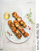 White cutting board with tasty Meat skewers on light rustic background, top view. Стоковое фото, агентство Ingram Publishing / Фотобанк Лори