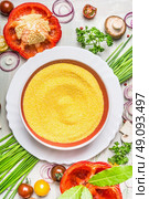 Polenta dish  and various vegetables and seasoning ingredients  for tasty vegetarian cooking on light  rustic wooden background, top view composing, close up. Healthy eating and diet food concept. Стоковое фото, агентство Ingram Publishing / Фотобанк Лори