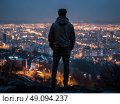 Крепкий парень стоит на вершине холма задом, Руки в кормане и смотрит на ночной город. Стоковое AI-изображение, AI-художник Сергей Татаринцев / Фотобанк Лори