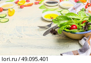 Healthy green salad dish with young lettuce leaves and various dressing ingredients on light wooden background. Healthy  lifestyle or detox diet food  concept. Стоковое фото, агентство Ingram Publishing / Фотобанк Лори
