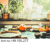 Kitchen scene with preparation of traditional festive pumpkin pie cooking on table at window, retro styled. Стоковое фото, агентство Ingram Publishing / Фотобанк Лори