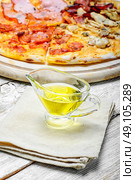 Olive oil for pizza. Gravy boat with olive oil on linen napkin to the pizza. Стоковое фото, агентство Ingram Publishing / Фотобанк Лори