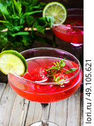 Mojito with lime and strawberry. alcohol cocktail in glass on a long stalk with strawberries and lime. Стоковое фото, агентство Ingram Publishing / Фотобанк Лори