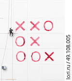 Maintenance worker play tick-tack-toe  outside a wall . Стоковое фото, агентство Ingram Publishing / Фотобанк Лори