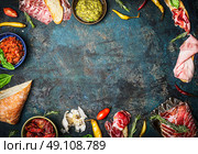 Ingredients for italian snack, bruschetta, crostini or sandwich bar with italian ham, sausage  and antipasto on rustic wooden background, top view, frame. Стоковое фото, агентство Ingram Publishing / Фотобанк Лори