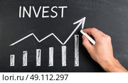 Concept of financial investment growth depicted with chalk drawing of bar graph and upward arrow on a blackboard. Стоковое AI-изображение, AI-художник Ольга Сухарева / Фотобанк Лори