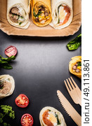 Vegetarian wraps on Paper plate and wooden cutlery, top view, frame. Healthy lunch or Street Food concept. Стоковое фото, агентство Ingram Publishing / Фотобанк Лори
