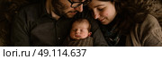 A man and a woman holding a baby in their arms, smiling lovingly at the infant. Стоковое AI-изображение, AI-художник Данила Большаков / Фотобанк Лори