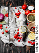 Seasoning for raw fish. Carcass raw fish on the kitchen table with spices. Стоковое фото, агентство Ingram Publishing / Фотобанк Лори