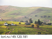 Alpine village in mountains. Smoke and haze over the hills in Carpathians. Стоковое фото, агентство Ingram Publishing / Фотобанк Лори