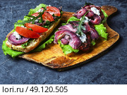 Baguette with bacon and vegetables. sandwiches with bacon and vegetables on blue slate background. Стоковое фото, агентство Ingram Publishing / Фотобанк Лори