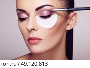 Makeup artist applies eye shadow. Beautiful woman face. Perfect makeup. Makeup detail. Beauty girl with perfect skin. Nails and manicure. Стоковое фото, агентство Ingram Publishing / Фотобанк Лори