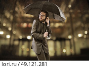 Afraid smart businessman standing under the umbrella. Стоковое фото, агентство Ingram Publishing / Фотобанк Лори