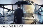 Elegant man holding a black umbrella. Стоковое фото, агентство Ingram Publishing / Фотобанк Лори