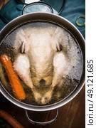 Whole boiled chicken in cooking pot with broth, soup preparation, top view. Стоковое фото, агентство Ingram Publishing / Фотобанк Лори