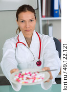 different pills in white plate in female doctors hands. Стоковое фото, агентство Ingram Publishing / Фотобанк Лори