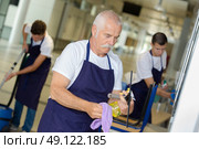 mature man cleaning building with younger team. Стоковое фото, агентство Ingram Publishing / Фотобанк Лори